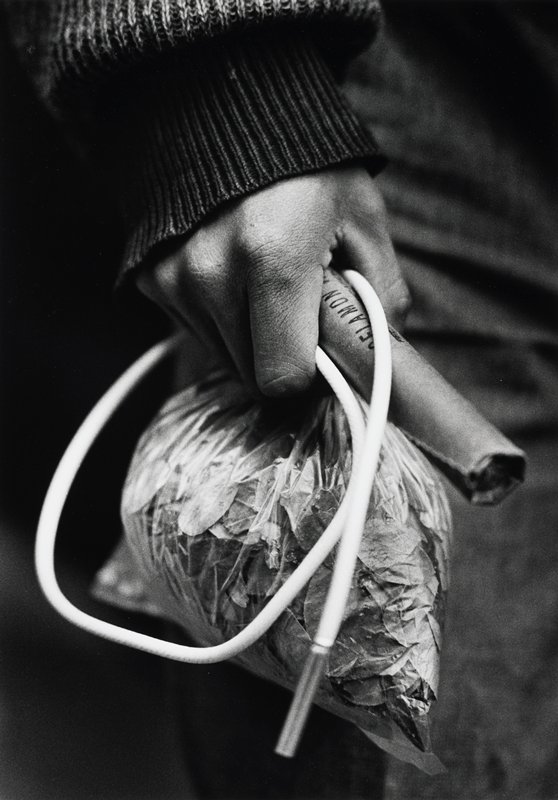 Bolivia Mineros, Entrando a la mina [hand holding bag of leaves and white tube], Jean-Claude Wicky, 1991