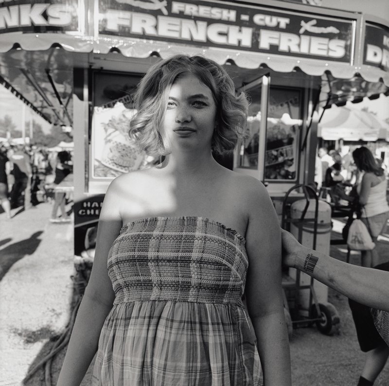 Pine City, MN [young woman wearing smocked plaid dress in front of French fry booth], Michael Dvorak