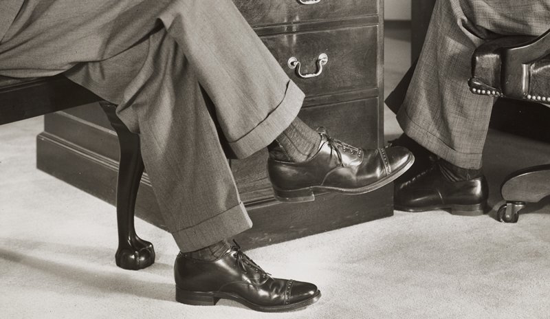 Two men in dress shoes at office desk, Edward W. Quigley, 1948