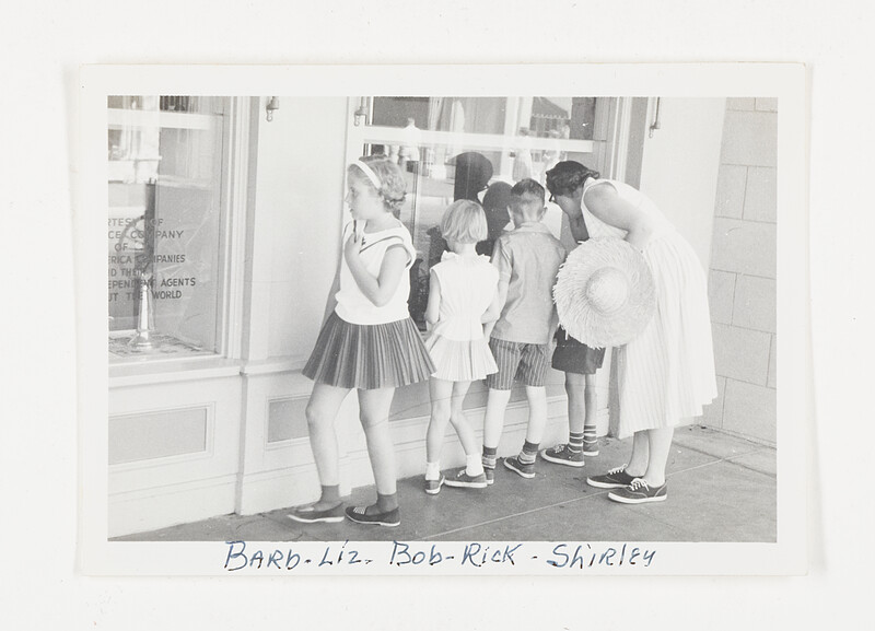 [Group looking into store window], c. 1955