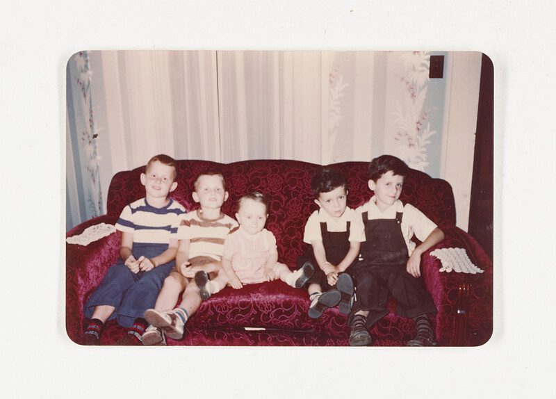 [Six children seated on a sofa], c. 1960