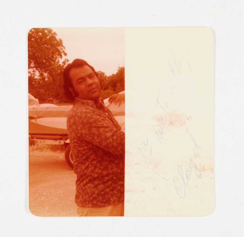 [Man in patterned shirt holding child], c. 1975