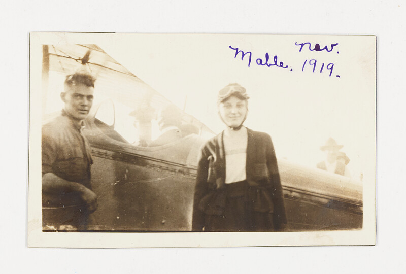 [Aviator and man beside biplane], 1919