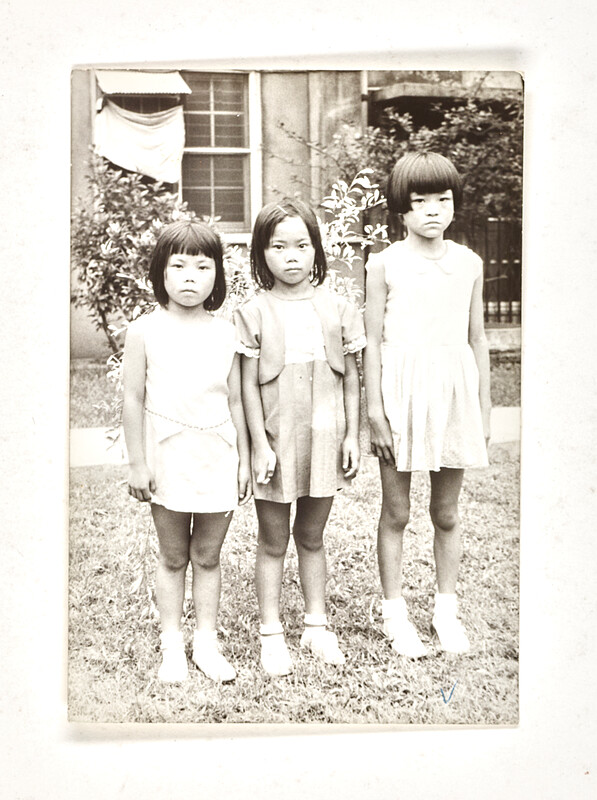 [Three girls standing in grass], 1973