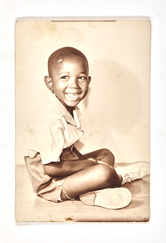[Smiling boy seated on floor], c. 1955