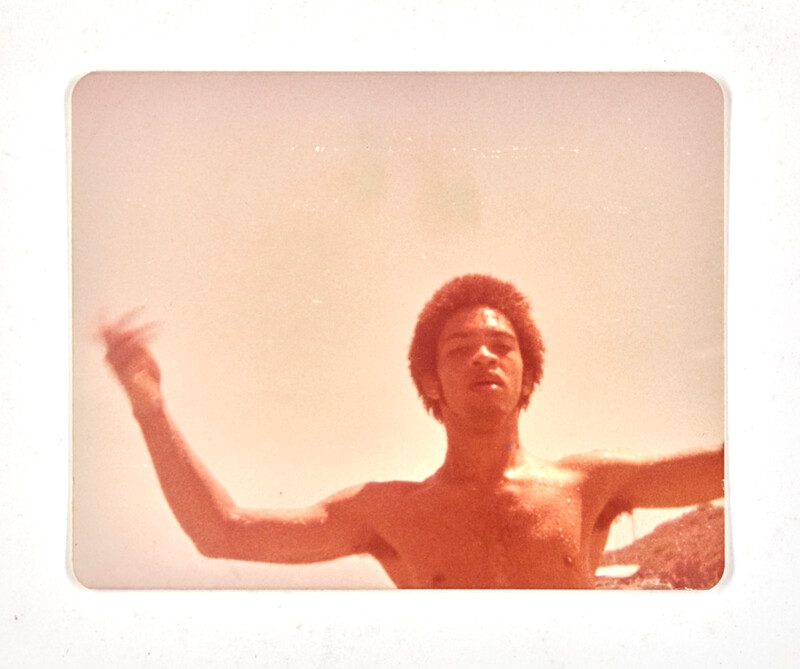 [Young man at the beach with arms raised], c. 1975
