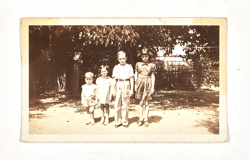 [Four children posing outdoors in shade], 1930s–40s